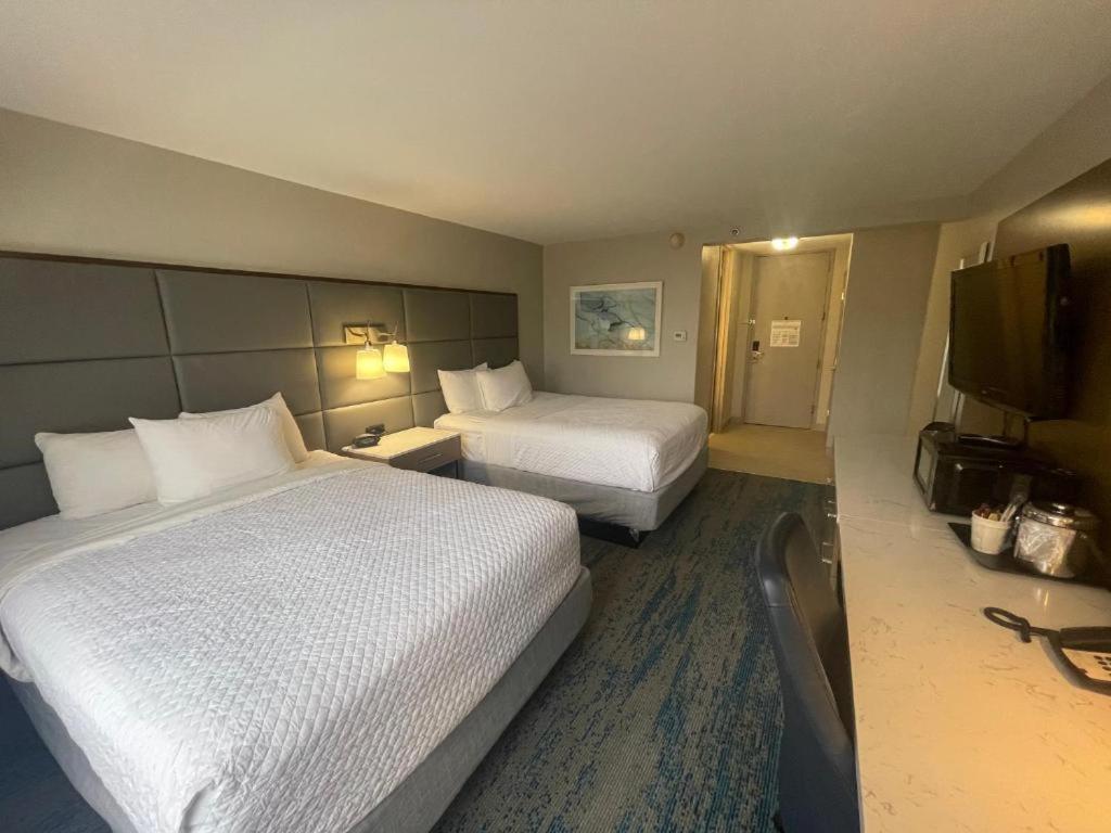 a hotel room with two beds and a flat screen tv at FairBridge Inn & Suites Independence in Cleveland