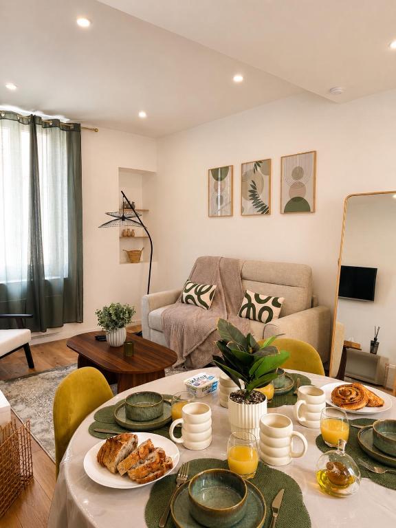 a living room with a table with food on it at Terrasse - CLIM - Arènes à pied - 4 pers in Nîmes