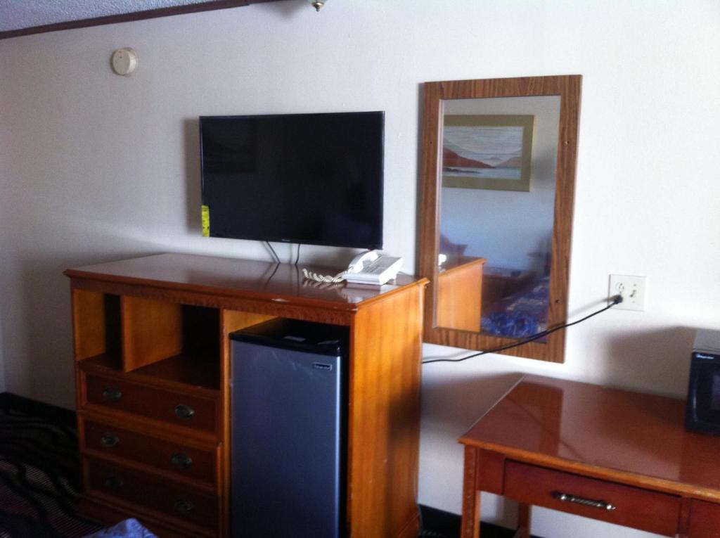 a room with a desk with a television and a mirror at Blue Stone Inn in Washington Court House