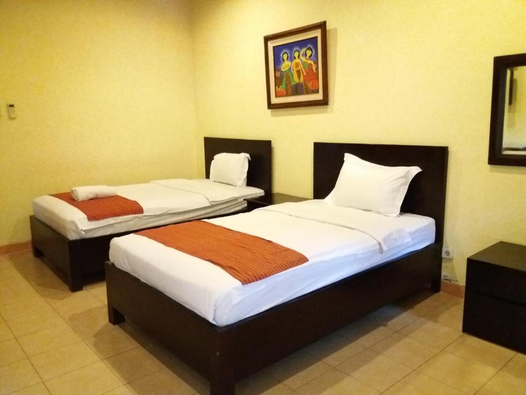 Postel nebo postele na pokoji v ubytování Alam Jogja Resort Mitra RedDoorz