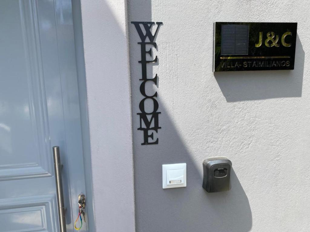 a door with a sign on the side of a building at Villa J&C-SAINT AIMILIANOS in Porto Heli