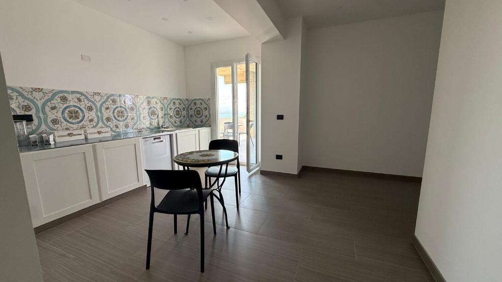 a kitchen with a table and chairs in a room at Torre Antica in Ioppolo