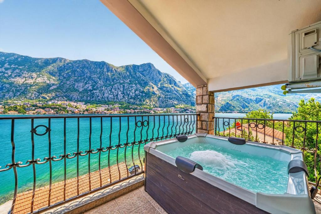 a hot tub on a balcony with a view of the water at Apartments Vuković in Kotor