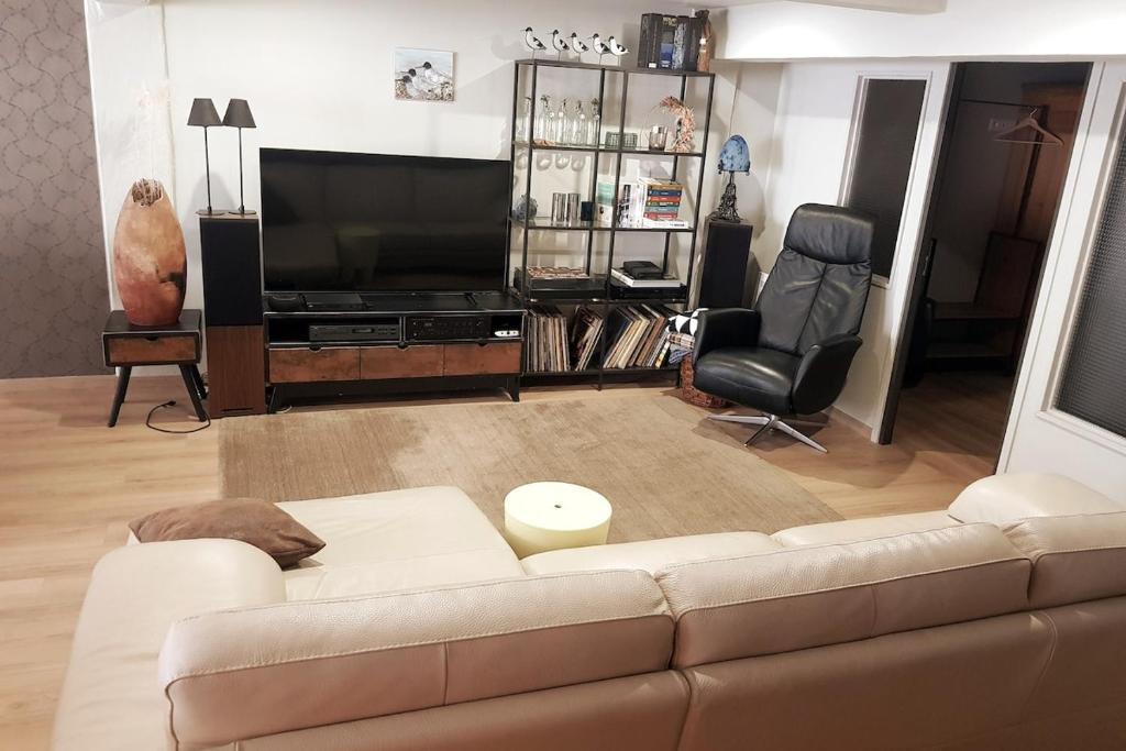 a living room with a couch and a television at Verborgen Pareltje in Bray-Dunes
