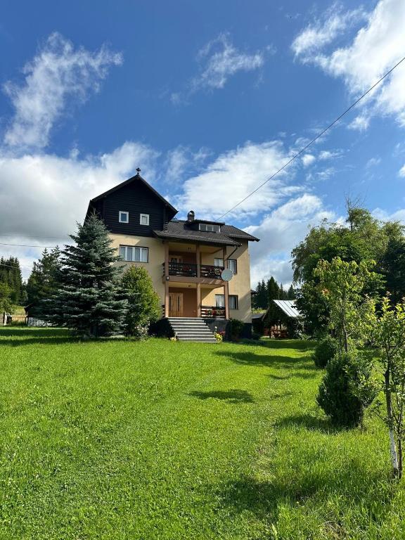 a house with a grassy yard in front of it at Casa Nico in Coşna