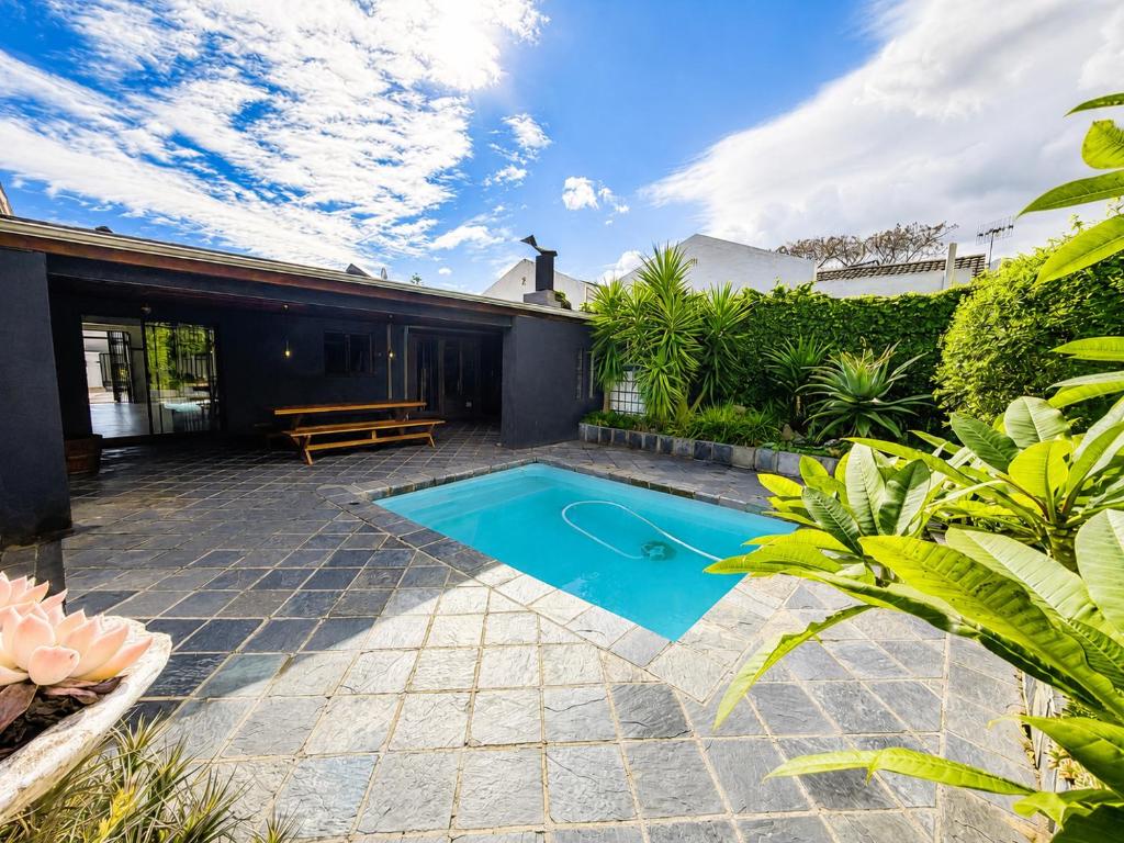 a swimming pool in the backyard of a house at Tivoli House in Edgemead