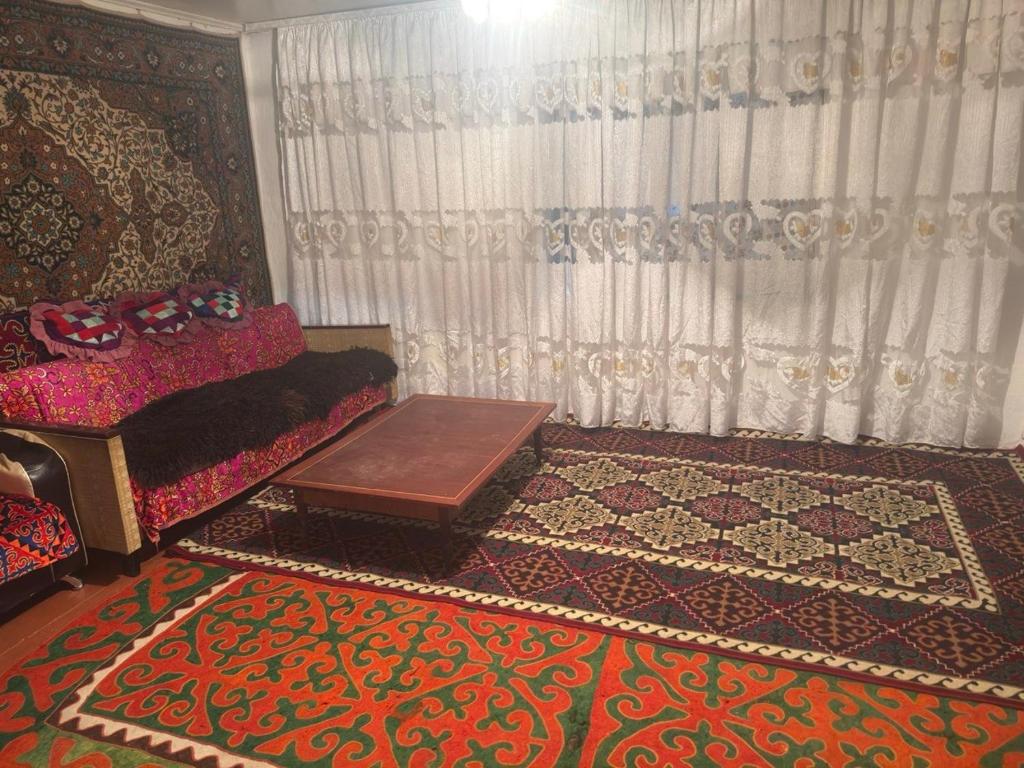 a living room with a couch and a table at Guesthouse Adis in Kyzart