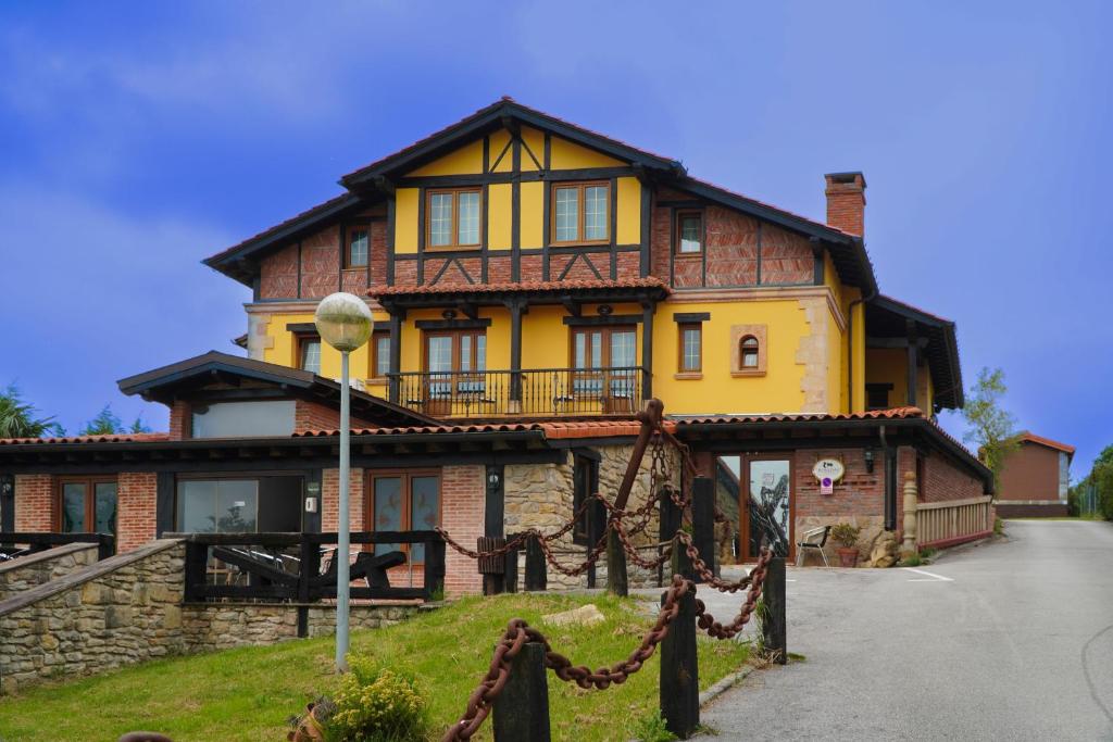 a large yellow and brown house on a hill at Posada El Valle - Adults Only in Suances
