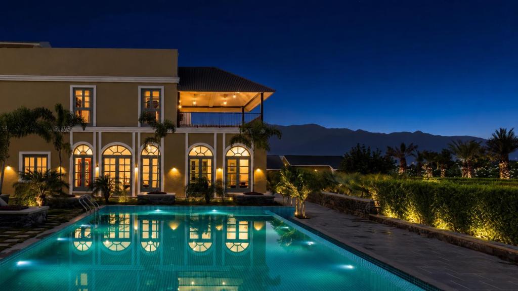 a house with a swimming pool at night at Merriment Luxury Resort & Private Pool Villa Near Mount Abu, Abu Road in Bhīmānia