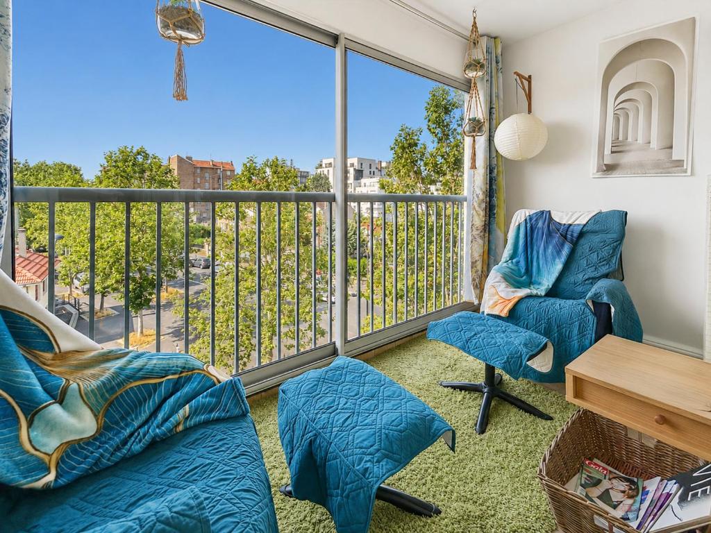 a room with a balcony with blue chairs and a table at La Parenthèse Loggia - Calme & proche Disney in Champigny-sur-Marne