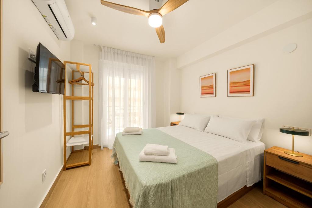 a white bedroom with a bed and a television at Jomarijo Boutique Rooms in Fuengirola