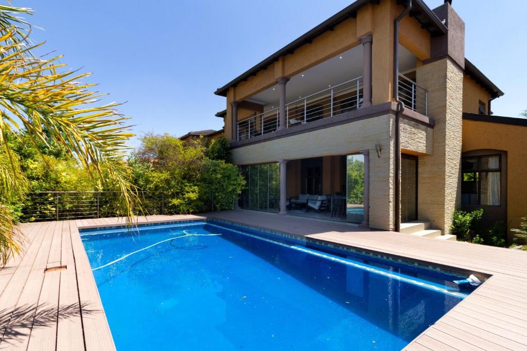a house with a swimming pool in front of a house at Alimama Spaces: Manson Mansion in Randjesfontein