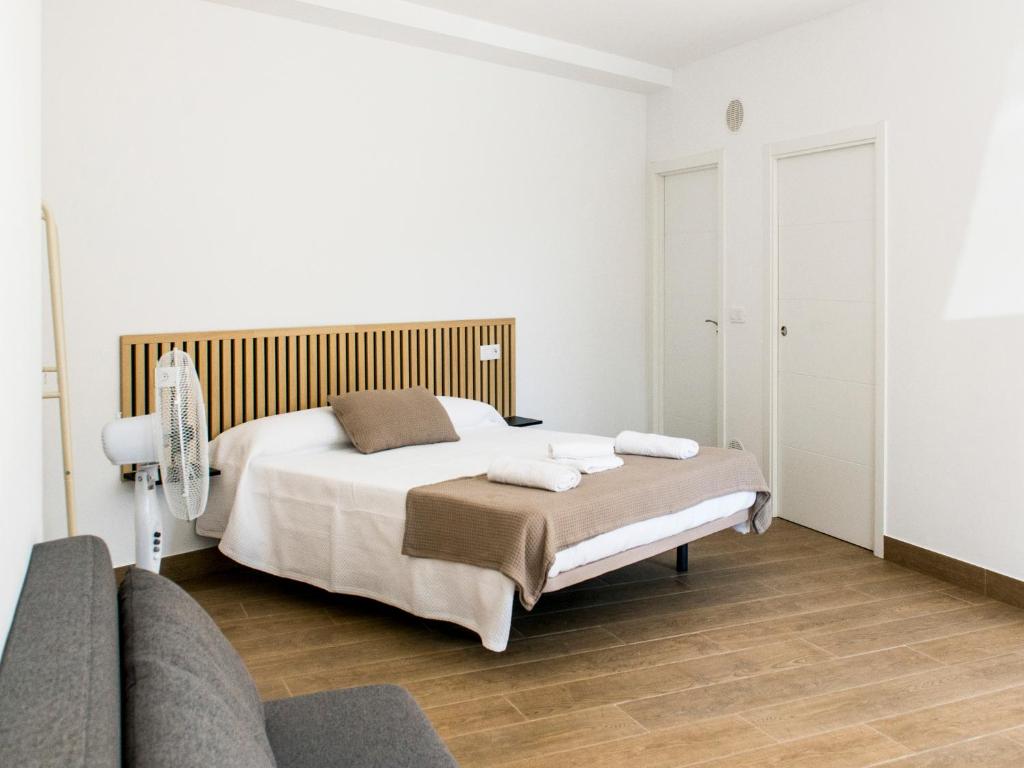 a white bedroom with a bed and a couch at A Calexa Sarria nº2 in Sarria