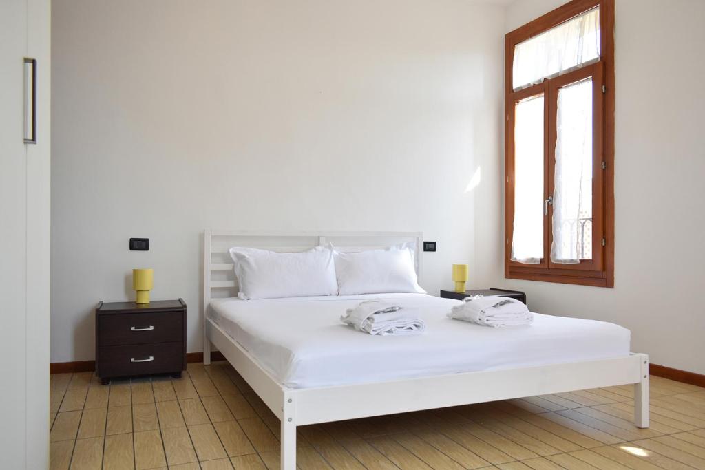 a white bed in a room with a window at Welc-ōM Conselve Matteotti in Conselve