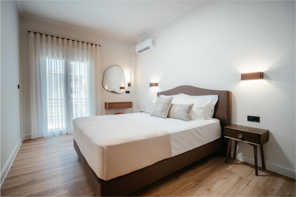a bedroom with a large bed and a mirror at Aida's Apartment Nafplio in Nafplio