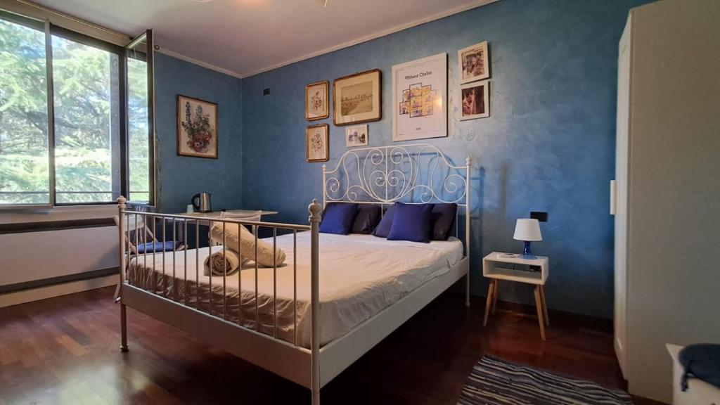 a bedroom with a bed with a blue wall at B&B La Dimora di Charme in Basiglio