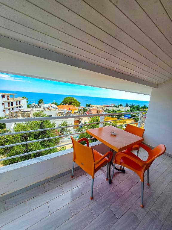 a table and chairs on a balcony with a view at Sunrise Dhermi Beach in Dhërmi