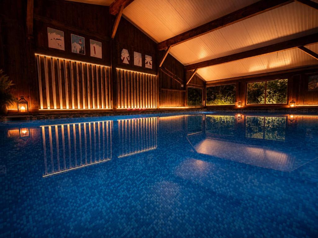 a large swimming pool in a house with lights at Hotel la Fontaine du Mont Blanc in Les Houches