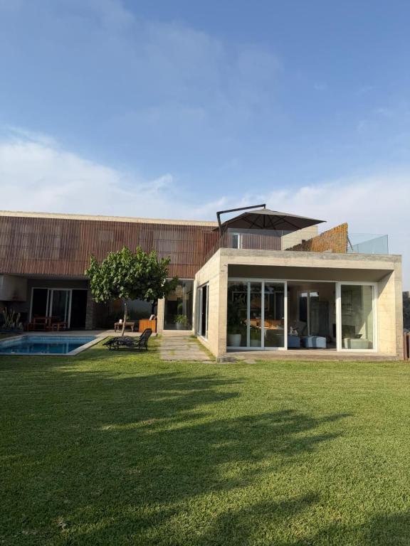a house with a lawn in front of it at Casa Catalina - Oceanfront house Lima in Lima