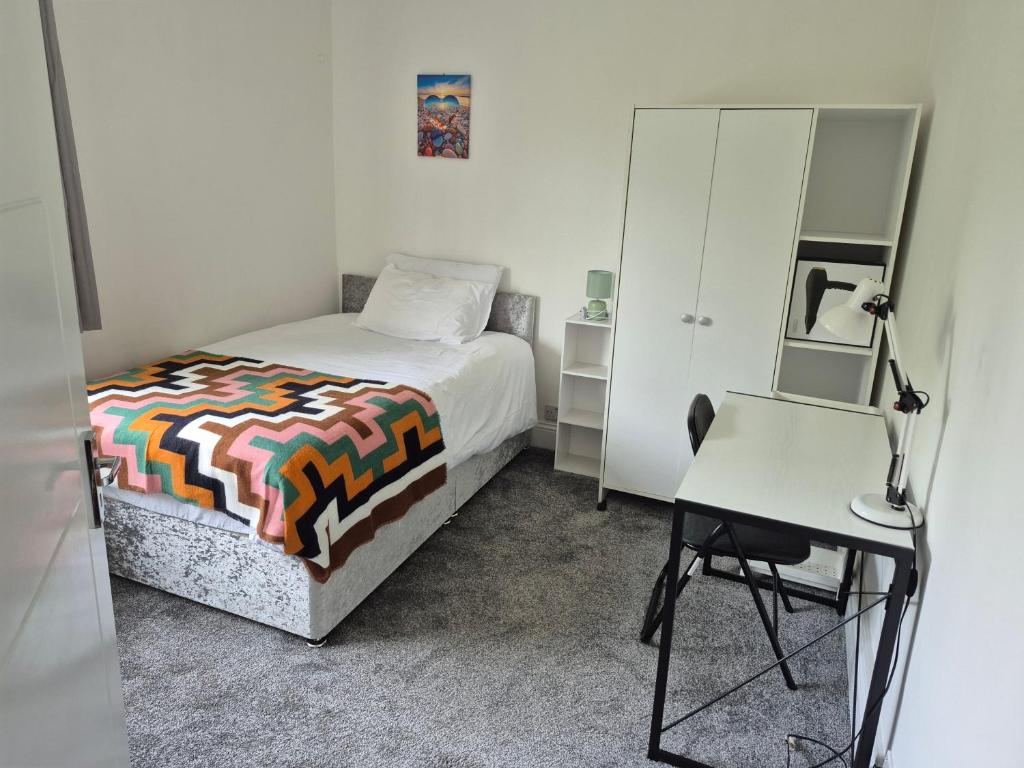 a bedroom with a bed and a desk and a mirror at private room with shared bathroom 20 minutes walk to Durham centre in Gilesgate