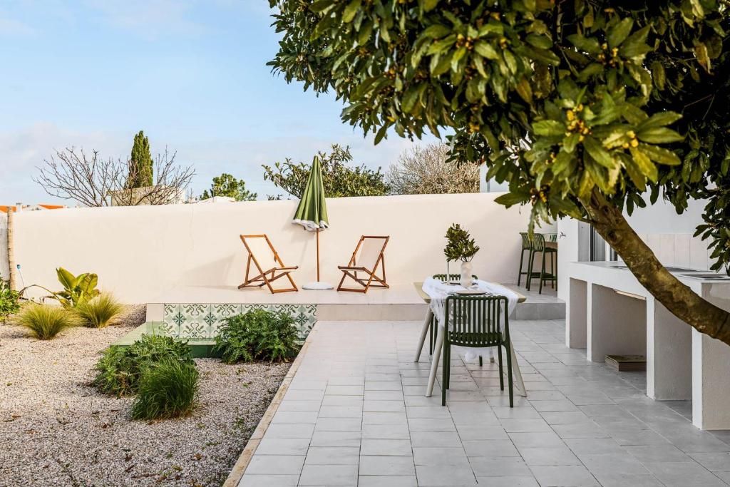 a patio with a table and chairs and a fence at Refúgio Do Loureiro in Sesimbra