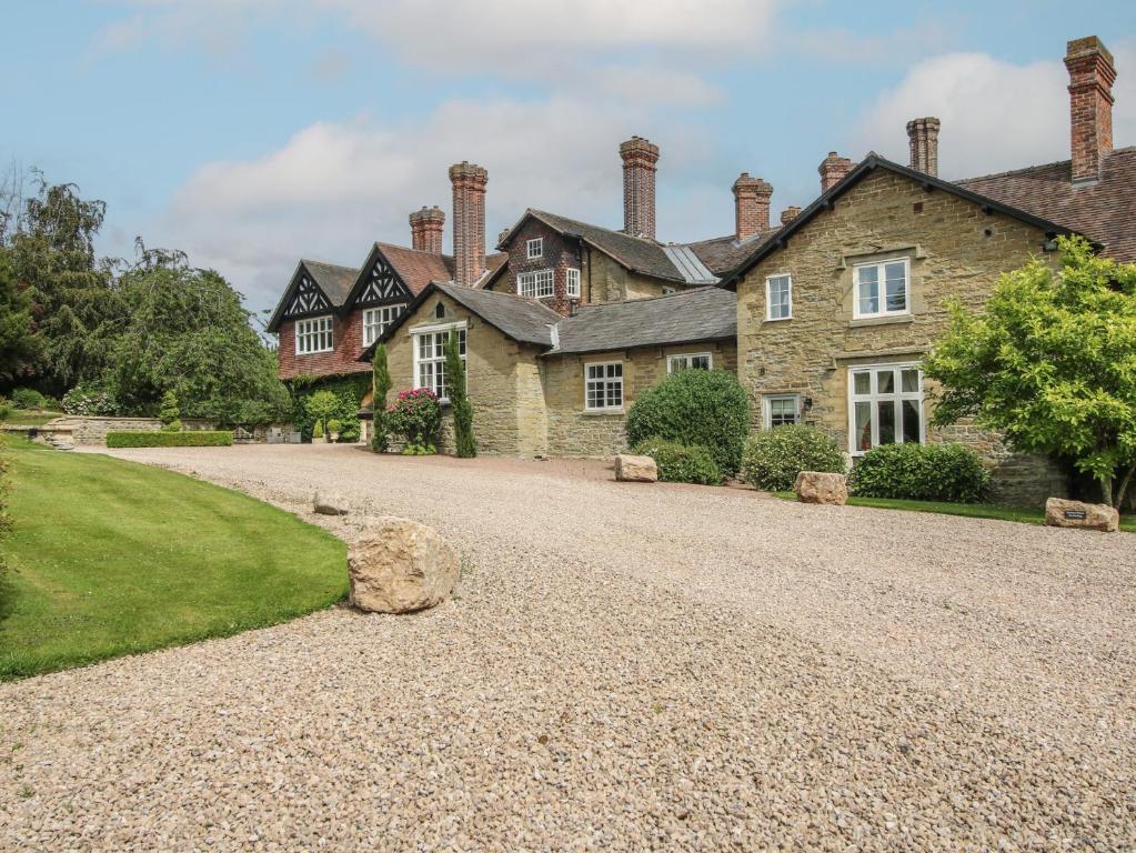 a large house with a gravel driveway at The Butlers Quarters in Much Wenlock