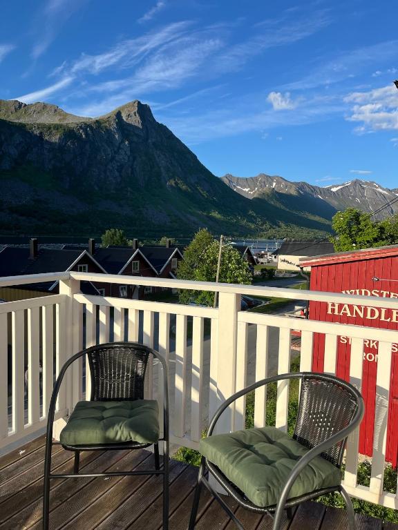 two chairs on a deck with mountains in the background at Senja Aurora Lodge in Senja