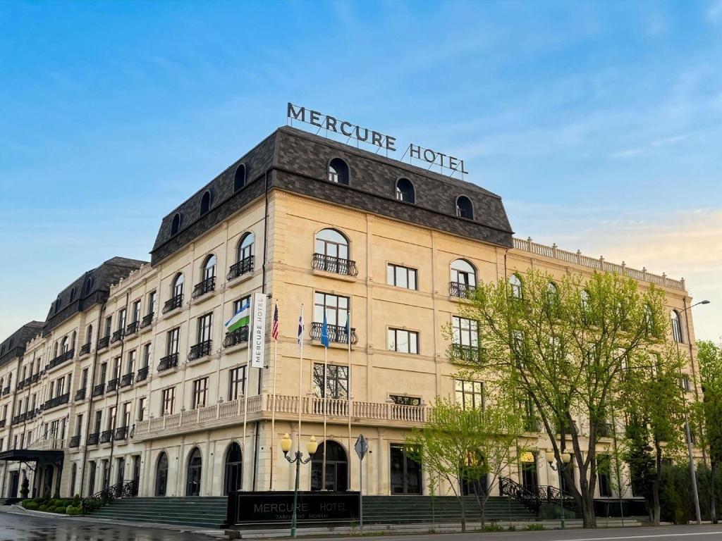 a building with a sign on the top of it at Mercure Tashkent North in Tashkent