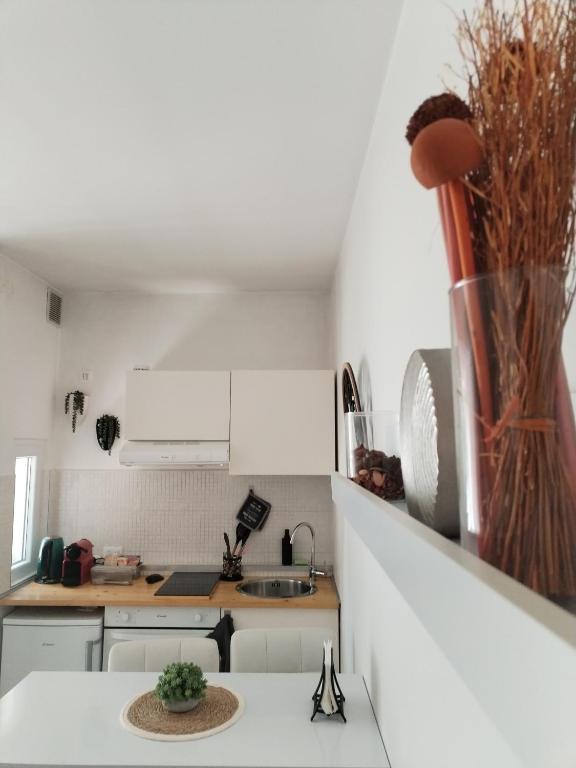 a kitchen with white cabinets and a vase on the counter at Mini Comfort House Udine in Udine