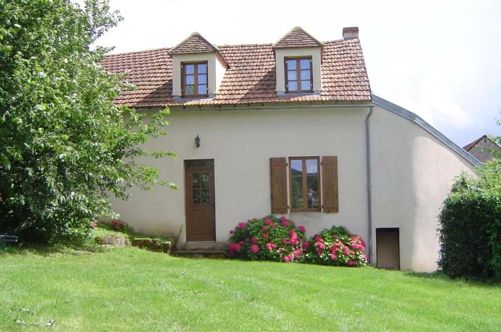 a white house with two windows and a yard at Gîte de la Savenée in Saint-André-en-Morvan