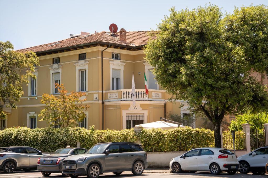 a building with cars parked in front of it at La Villa in Siena