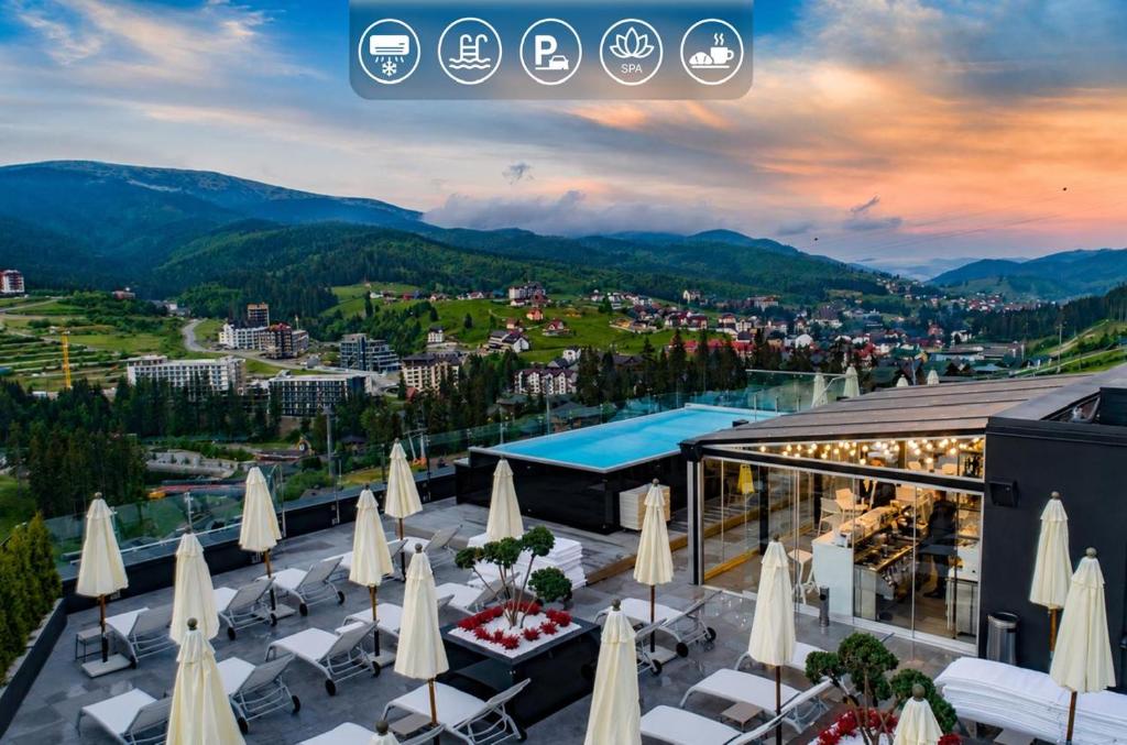 a view of a resort with tables and umbrellas at Mountain Residence Apartments & Chalet in Bukovel
