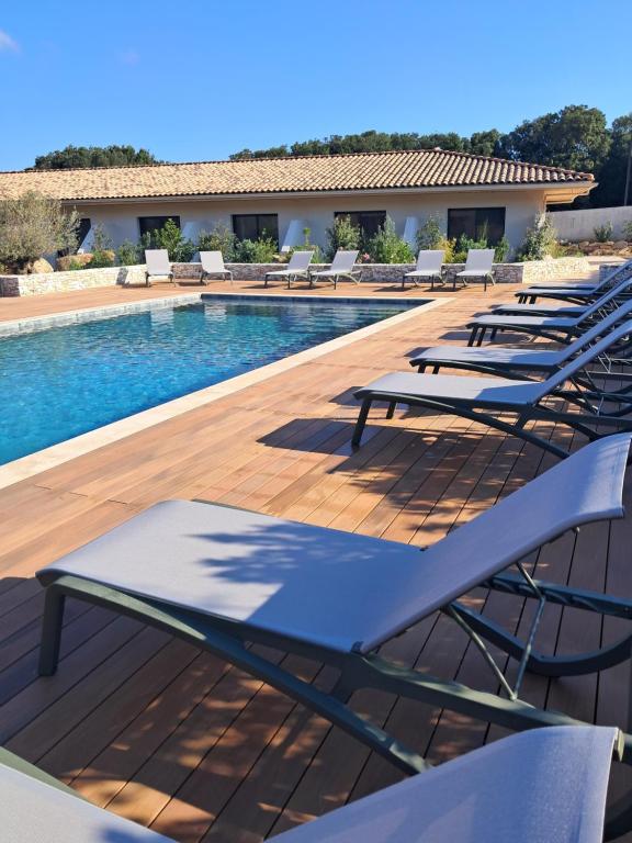 a row of lounge chairs next to a swimming pool at Hotel Fazio in Bonifacio