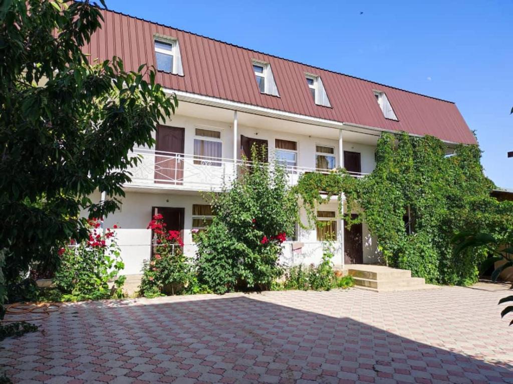 a building with a red roof and a brick driveway at Aiperii in Bosteri