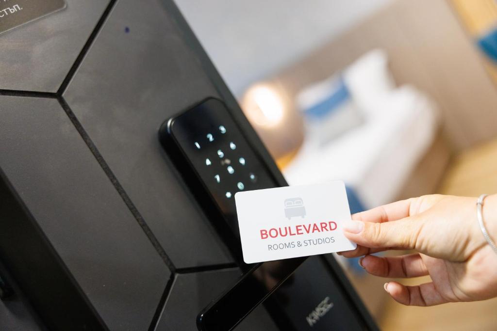 a person holding a card next to a remote control at Boulevard Hotel in Aytos