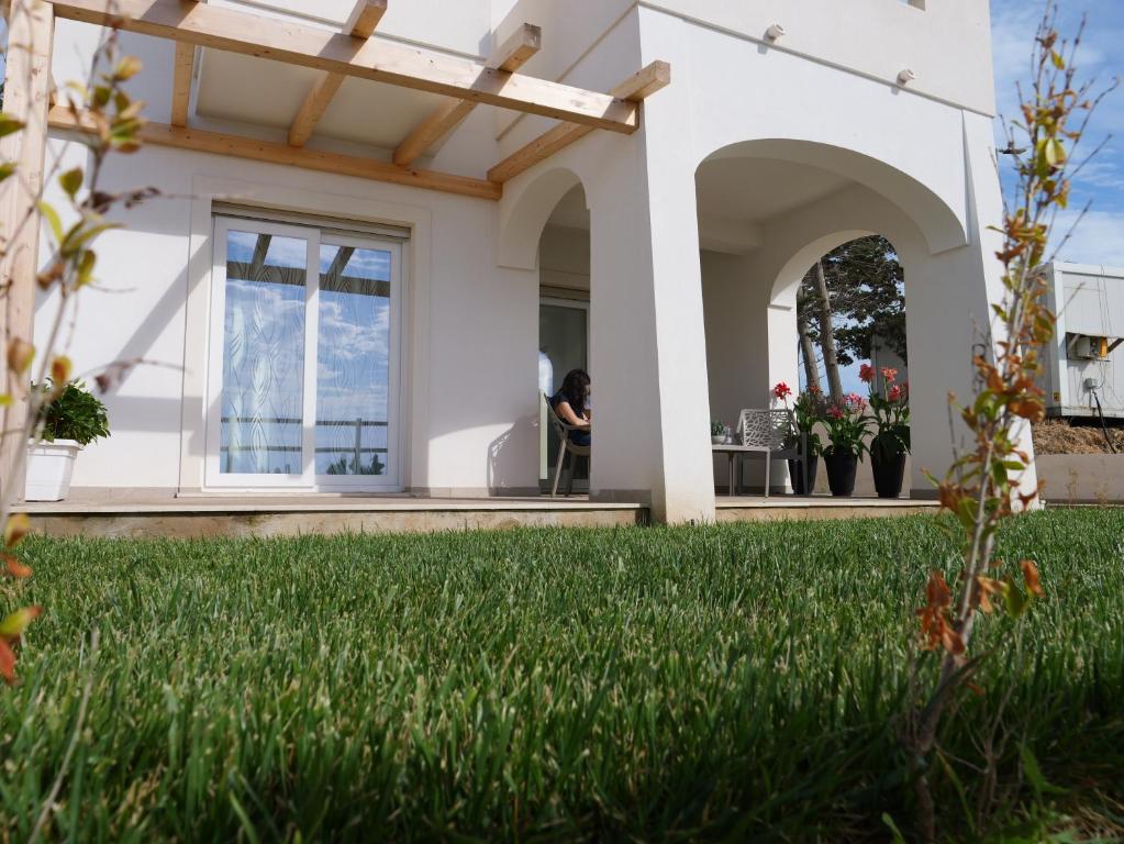 a woman sits on the porch of a house at Mgd House in Santa Domenica