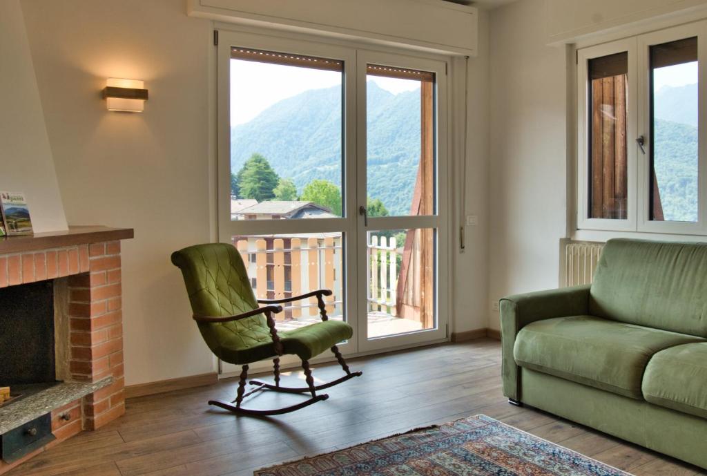 a living room with a couch and a chair and a fireplace at Casa Rachele - mountain panorama in Cassina Valsassina