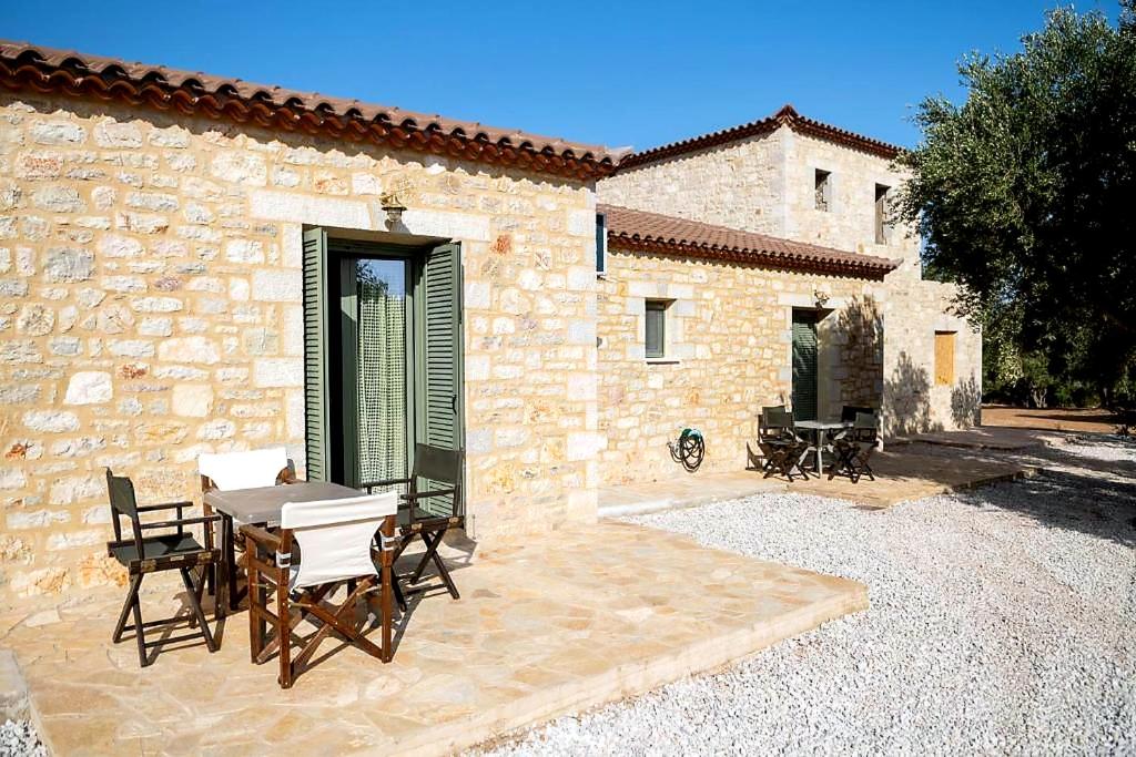 a patio with a table and chairs in front of a building at Olive Coast Houses in Kyparissia