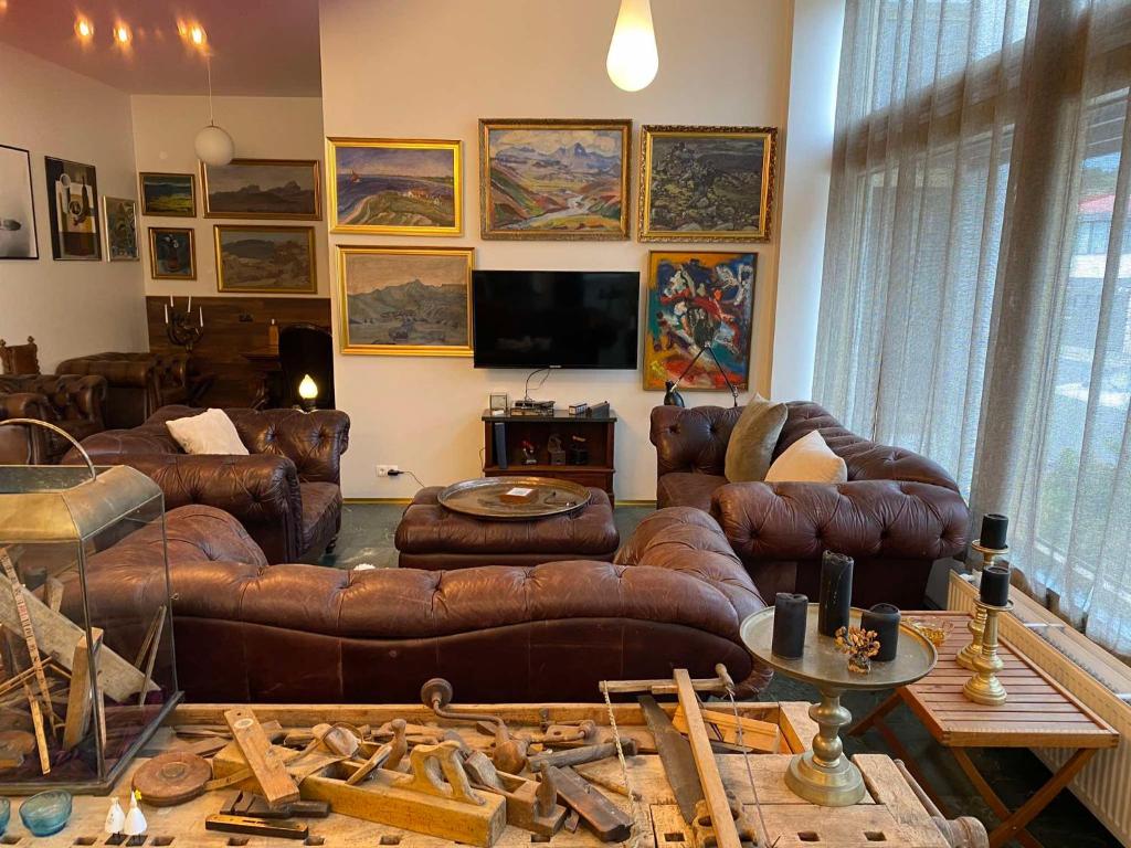 a living room with leather couches and a flat screen tv at City Hall Apartments in Borgarnes