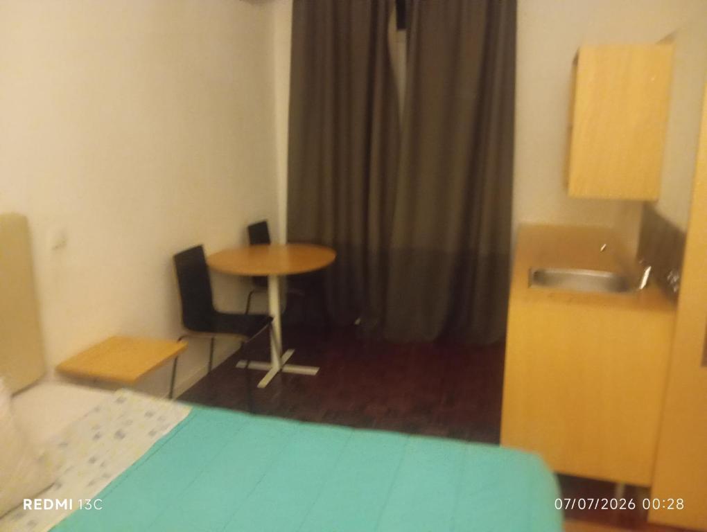 a room with a table and a table and a sink at Telhado solitario in Porto