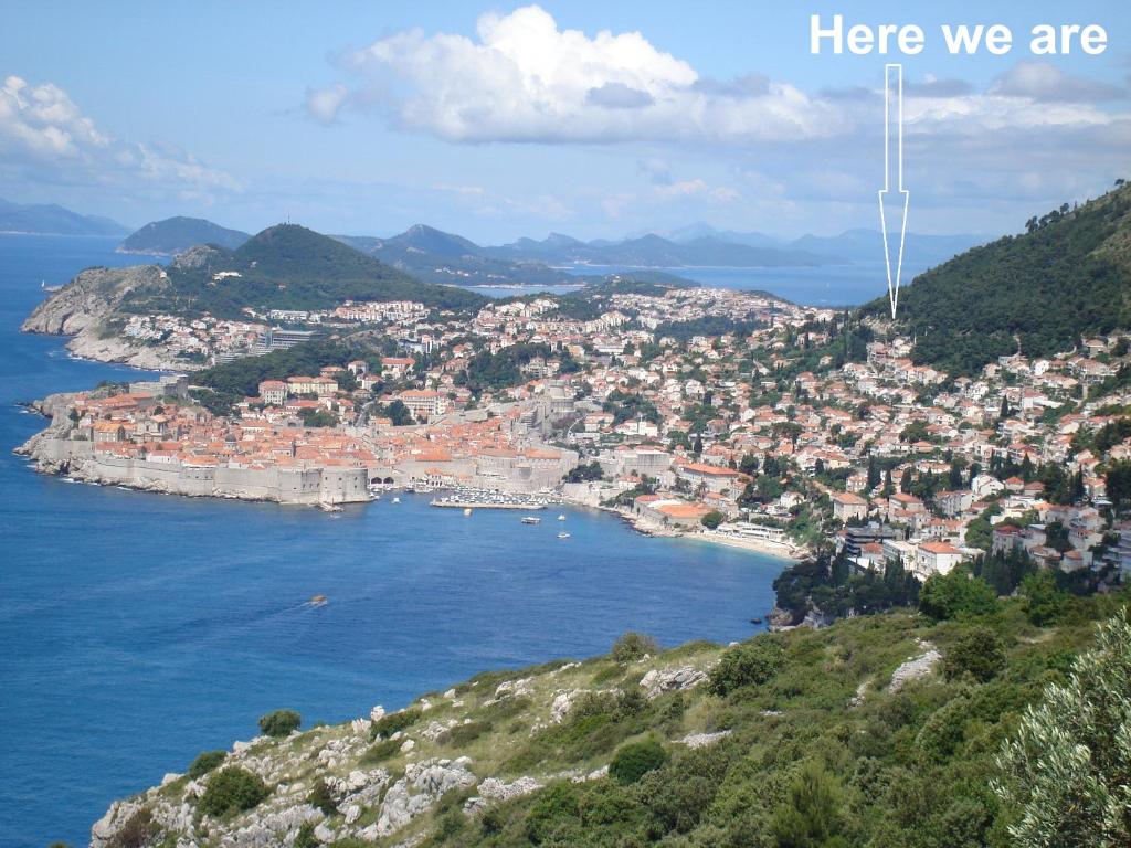 a town on a hill with the words here we are at Apartments Villa Kosovic - ground floor in Dubrovnik