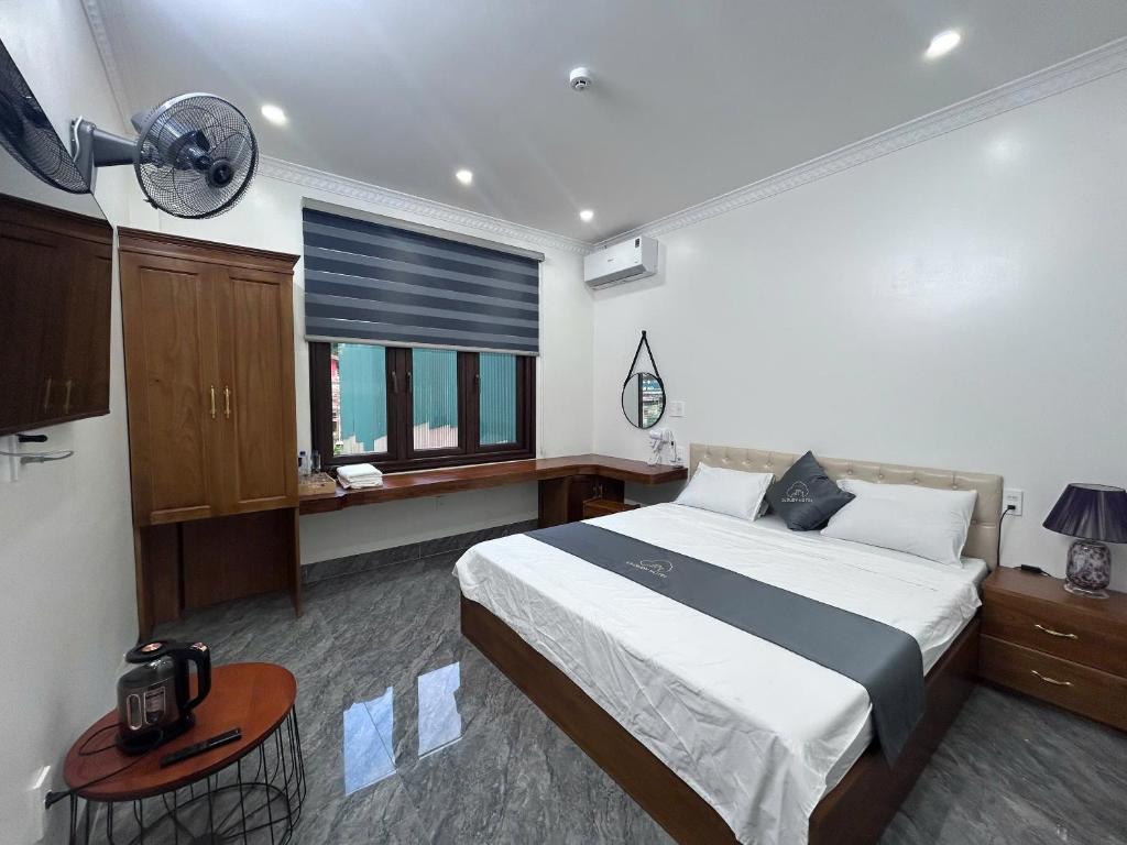 a bedroom with a bed and a desk and a window at Cloudy Hotel in Ha Giang