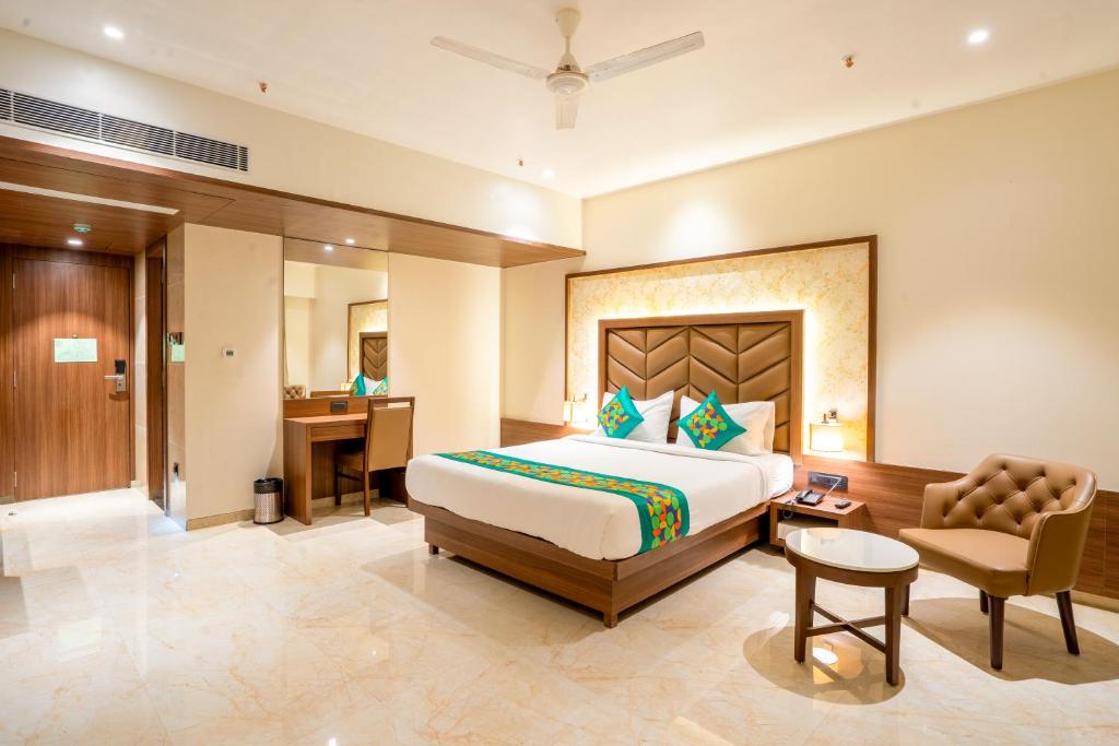 a hotel room with a bed and a desk at Treebo Premium Merrit in Katrab