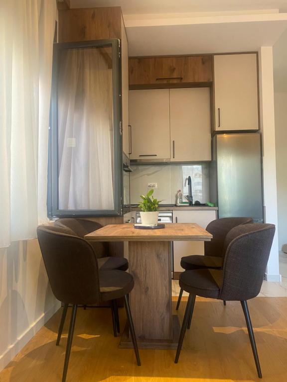 a kitchen with a wooden table and chairs in a room at BIJELA apartman 2025 in Bijela