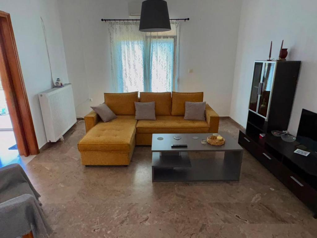 a living room with a couch and a coffee table at Village Memories in Koronópoulon