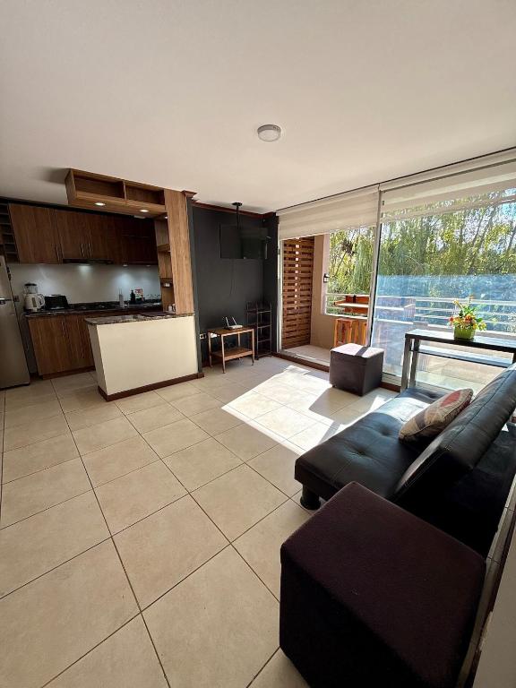 a living room with a couch and a kitchen at Departamento Amplio y tranquilo in Talca