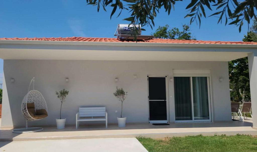 a white house with a bench and a chair at Boutique Villa Sofia in Limenas