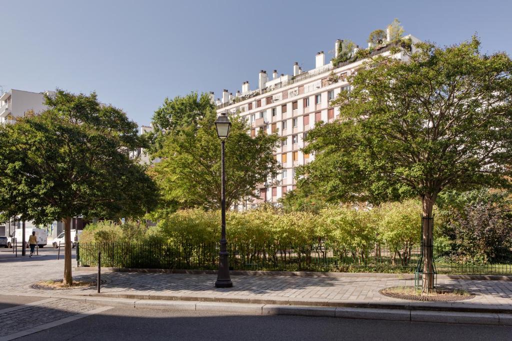 a street light in front of a building with trees at Villa Lutèce Port Royal in Paris