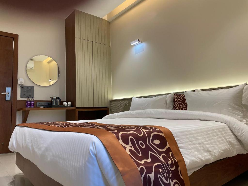 a bedroom with a large bed with a brown and white blanket at Hotel Vishwaraj Residency in Solapur