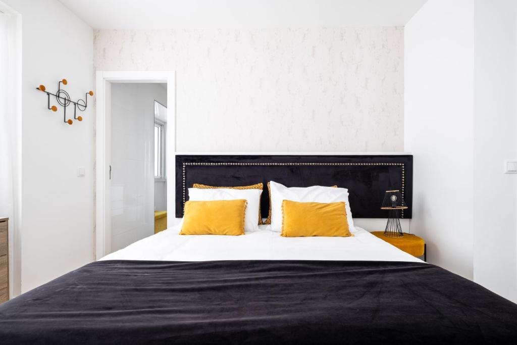 a bedroom with a large bed with yellow pillows at Alojamento Local Vitoria in Batalha